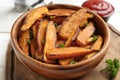 Bowl with tasty sweet potato fries on wooden board Royalty Free Stock Photo