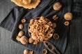 Bowl with tasty walnuts on dark table