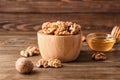 Bowl with tasty walnuts on wooden table