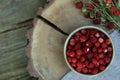 Bowl and tasty wild strawberries on wooden stump, top view. Space for text