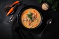 A bowl of thai chicken soup with carrots and coconut milk on a black table. AI generation