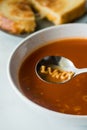 A bowl of tomato alphabet soup with the word lunch spelled out in the spoon.