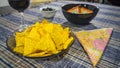 Bowl of tuna salad, tortilla chips, olives and glass of red wine