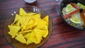 Bowl of tuna salad, tortilla chips, olives and glass of red wine