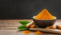 Bowl with turmeric powder on wooden table. Raw curcumin roots