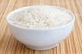 Bowl of uncooked white long grain rice on a bamboo Royalty Free Stock Photo