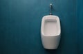 Bowl urinal white ceramic stall on the color pastel wall blue color Royalty Free Stock Photo