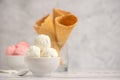 Bowl of vanilla and pink berries ice cream and waffle cones on light background. Side view. With copy space Royalty Free Stock Photo