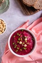 Bowl of vegetable beetroot hummus with chickpeas and herbs on the table top and vertical view Royalty Free Stock Photo