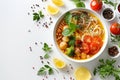 Bowl of vegetable noodle soup with tomatoes, broccoli, and chickpeas, garnished with herbs. Flat lay composition with Royalty Free Stock Photo