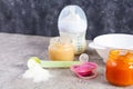 Bowl with vegetables puree and bottle of baby food on gray background Royalty Free Stock Photo