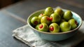 A bowl of vibrant green olives stuffed with ruby red peppers on a rustic table setting. Generative AI Royalty Free Stock Photo