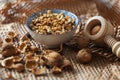 A bowl of walnuts placed on a table with shells and a wooden nutcracker lying around in a rustic style Royalty Free Stock Photo