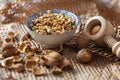 A bowl of walnuts placed on a table with shells and a wooden nutcracker lying around in a rustic style Royalty Free Stock Photo