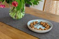 Bowl with walnuts and vase with tulips on wooden table indoors