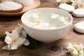 Bowl with water and beautiful jasmine flowers on wooden table Royalty Free Stock Photo