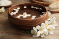 Bowl with water and beautiful jasmine flowers on table Royalty Free Stock Photo