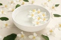 Bowl with water and beautiful jasmine flowers on white wooden table Royalty Free Stock Photo