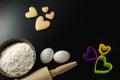Bowl with wheat flour, rolling pin, eggs and cookie cutters Royalty Free Stock Photo