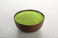 Bowl of wheat grass powder on white table Royalty Free Stock Photo