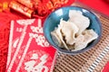 A bowl of white dumplings and new year`s red envelopes in the red background. The Chinese characters in the picture mean `happines