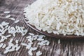 A bowl of white rice against the background of old boards near sprinkled rice. Jasmine rice for cooking Royalty Free Stock Photo