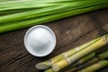 Bowl of white sugar with sugar cane on wood table . Royalty Free Stock Photo