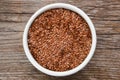 Bowl of whole flax seeds. Mortar of linseeds on wooden table.