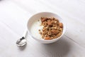 Bowl of whole grain granola with yogurt on white background, top view Royalty Free Stock Photo