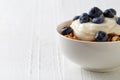 Bowl of whole grain muesli with blueberries and yogurt on white Royalty Free Stock Photo