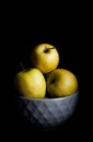 Bowl of yellow apples. On black background. Royalty Free Stock Photo