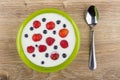 Bowl with yogurt, blueberries, raspberries, strawberries and spoon on table Royalty Free Stock Photo