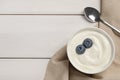 Bowl of yogurt with blueberries served on white wooden table, flat lay. Space for text Royalty Free Stock Photo