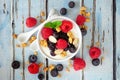 Bowl of yogurt with healthy fresh berries and granola, close up top view over blue wood Royalty Free Stock Photo