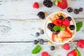 Bowl of yogurt with healthy fresh berries and granola, top view with ingredients on a blue wood background Royalty Free Stock Photo