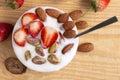 Bowl of yogurt, red fruit strawberry and dried fruit on the wood table. Yogurt made from milk fermented by added bacteria, often Royalty Free Stock Photo