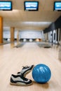 Bowling ball and house shoes on wooden floor