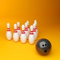 Bowling ball and pins on yellow background