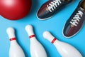 Bowling ball, shoes and pins on light blue background Royalty Free Stock Photo