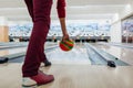Bowling game. Man having fun playing bowling in club throwing ball on lane. Close up of legs and shoes Royalty Free Stock Photo