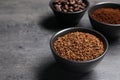 Bowls of beans, instant and ground coffee on grey table, closeup. Space for text Royalty Free Stock Photo
