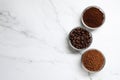 Bowls of beans, instant and ground coffee on white marble table, flat lay. Space for text Royalty Free Stock Photo