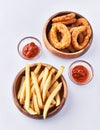 Bowls of breaded onion rings and potato chips isolated on a white background Royalty Free Stock Photo