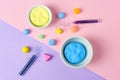 Bowls with bright play dough and shiny glitter on color background, flat lay