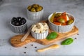 Bowls with delicious feta cheese, green and black olives, stuffed round peppers on a wooden board Royalty Free Stock Photo