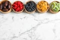 Bowls of different dried fruits on marble background, top view with space for text. Royalty Free Stock Photo