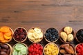 Bowls of different dried fruits on wooden background, top view with space for text Royalty Free Stock Photo