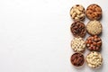 Bowls with different organic nuts and space for text on wooden background, top view. Snack mix