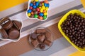 Bowls filled with different kinds of brown and colorful chocolates of different colors and shapes