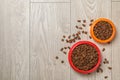 Bowls with food for cat and dog on wooden background Royalty Free Stock Photo